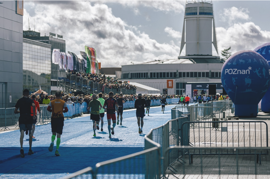Biegacze na trasie biegu dobiegają do mety na Placu Międzynarodowych Targów Poznańskich.