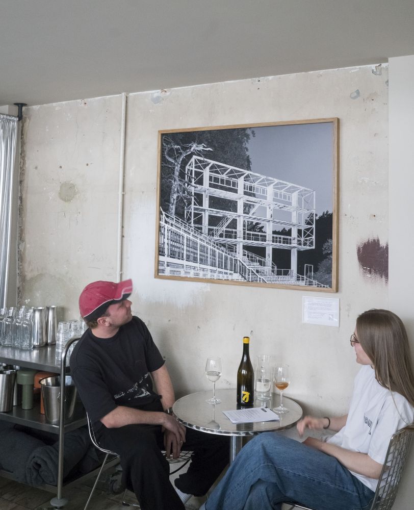 Chłopak i dziewczyna piją wino przy stoliku.