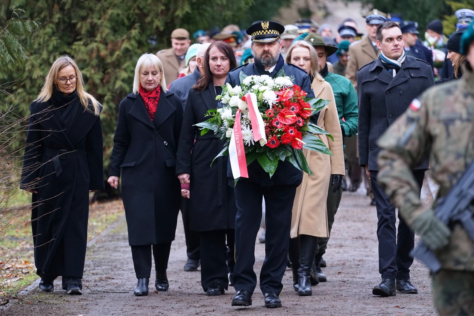 Członkowie delegacji składają kwiaty.