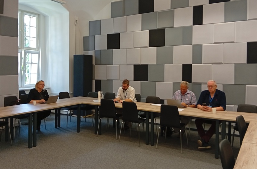 cztery osoby siedzą za stołem w sali konferencyjnej