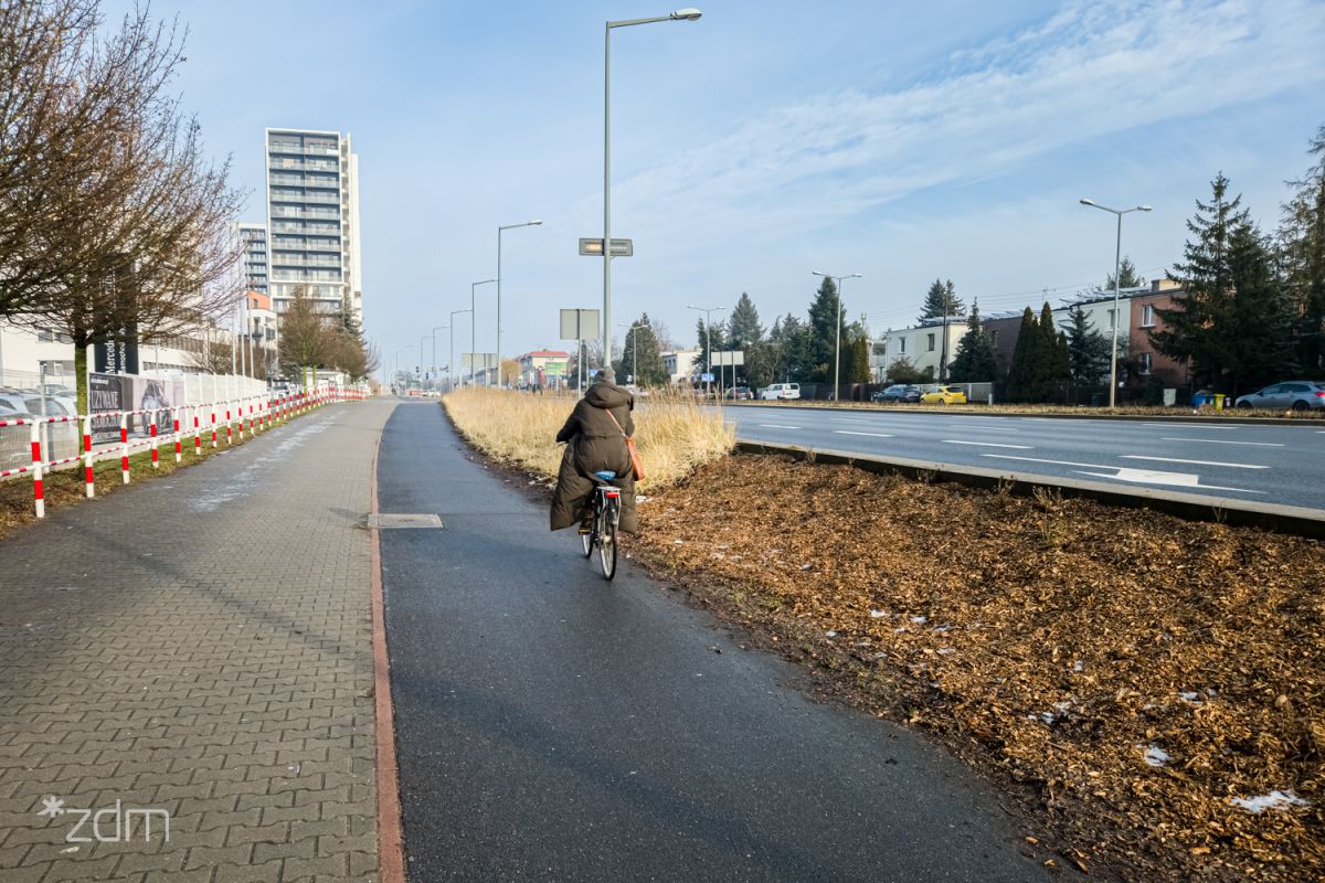 Droga pieszo-rowerowa a na niej jadący rowerzysta.