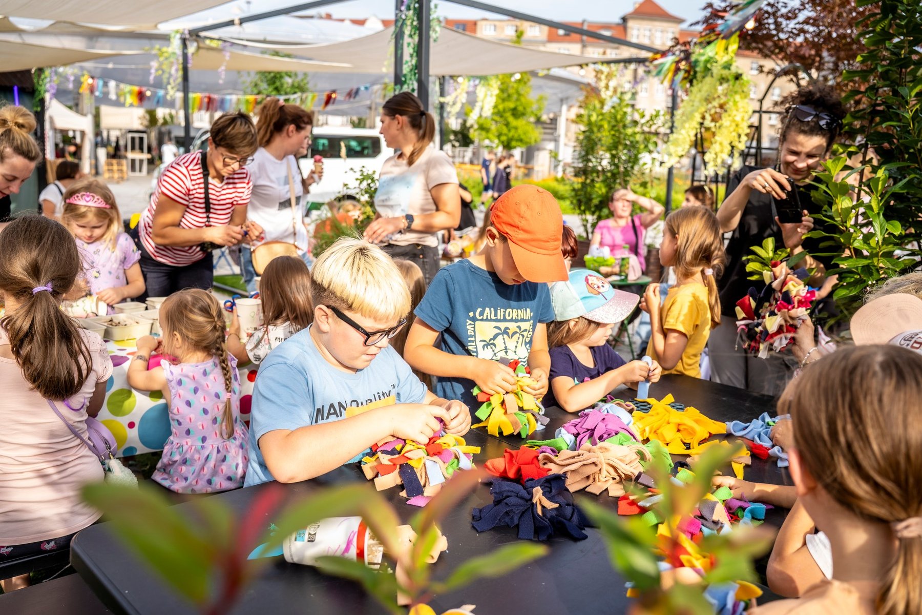 Dzieci przy stole robią robótki ręczne.