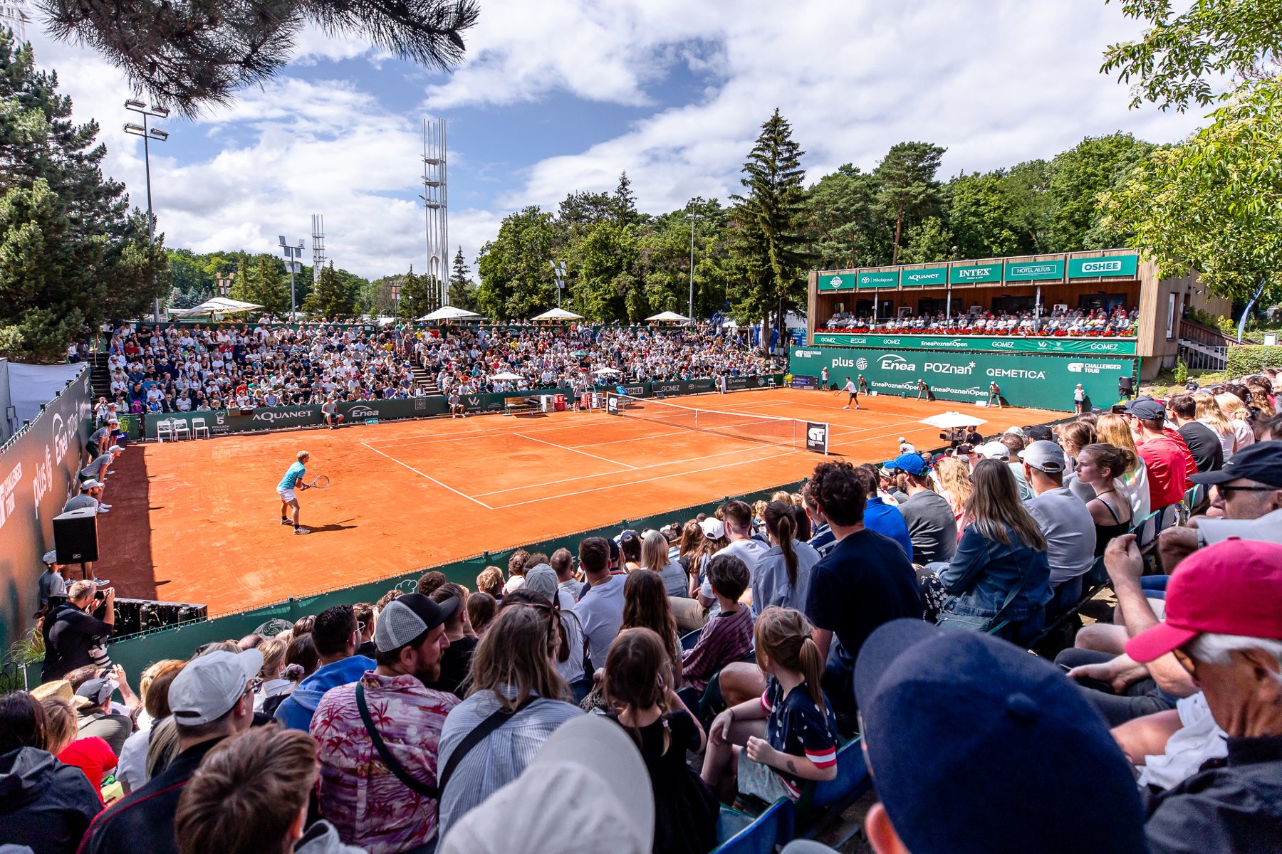 Enea Poznań Open 2024, fot. Paweł Rychter - zdjęcie z boku kortu. Zawodnicy szykują się do serwisu, a na trybunach jest komplet. Mecz rozgrywany jest w słonecznej aurze