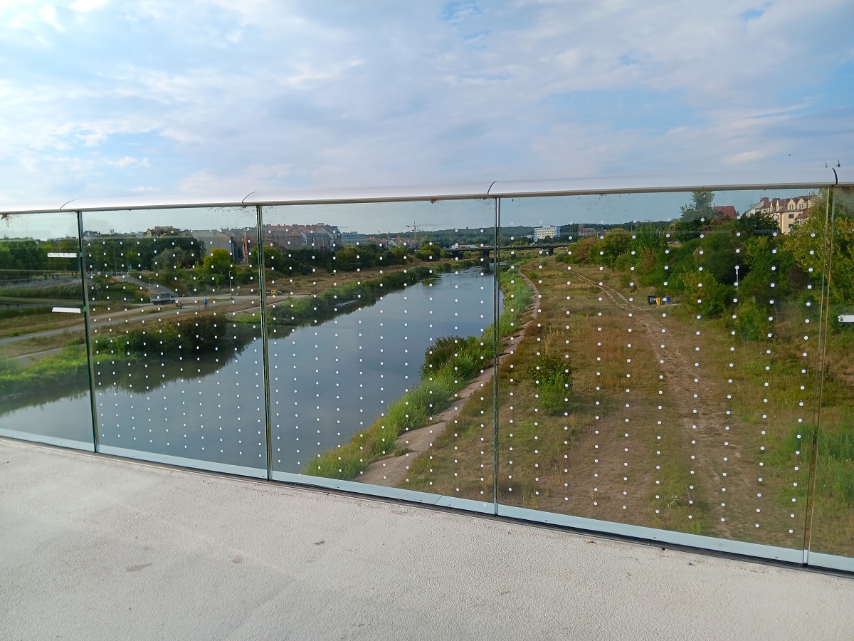 Folia z widocznymi kropkami naklejona na fragmenty szklane balustrady mostu