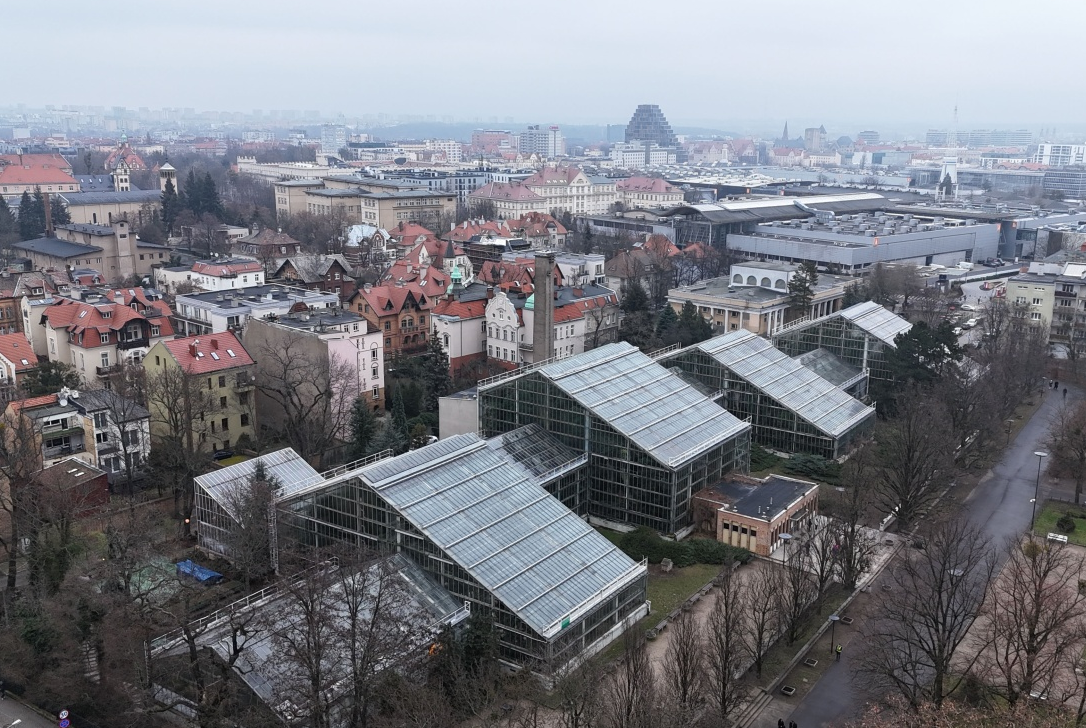 fragment panoramy miasta, widoczna zabudowa śródmiejska, kamienice oraz przeszklone pawilony, na dalszym planie wyższe biurowce