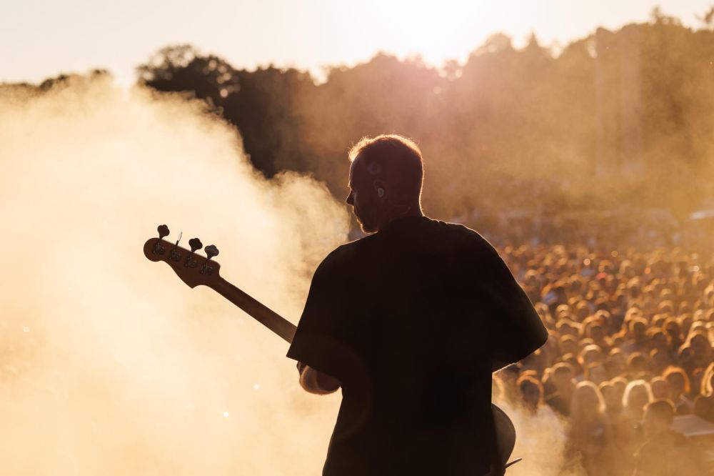 Gitarzysta na plenerowej scenie podczas występu.