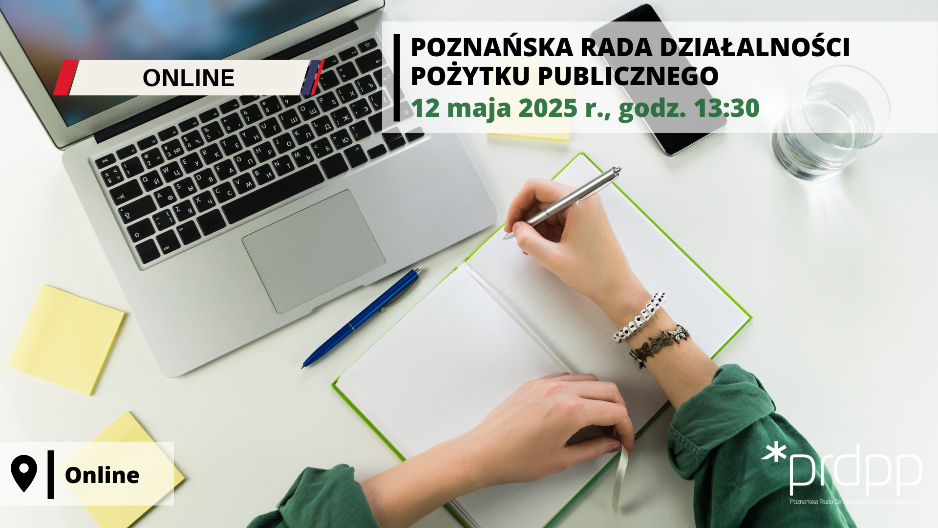 grafika przedstawia rzut z góry na biurko, na nim otwarty laptop, kartki dookoła, osoba siedząca za biurkiem, pracująca przy komputerze, trzyma w prawej ręce długopis, druga ręka położona na notatniku, w którym pisze, w zielonej bluzce, widoczne jedynie ręce na blacie