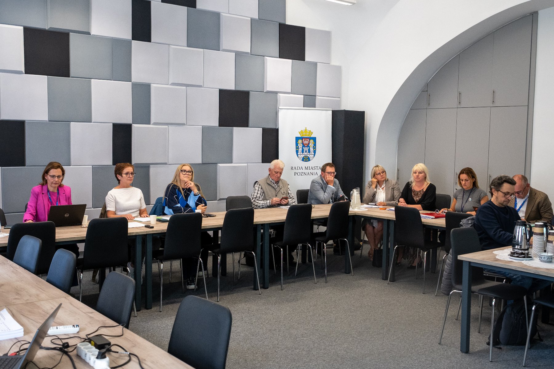 kilka osób obraduje za stołem w sali konferencyjnej