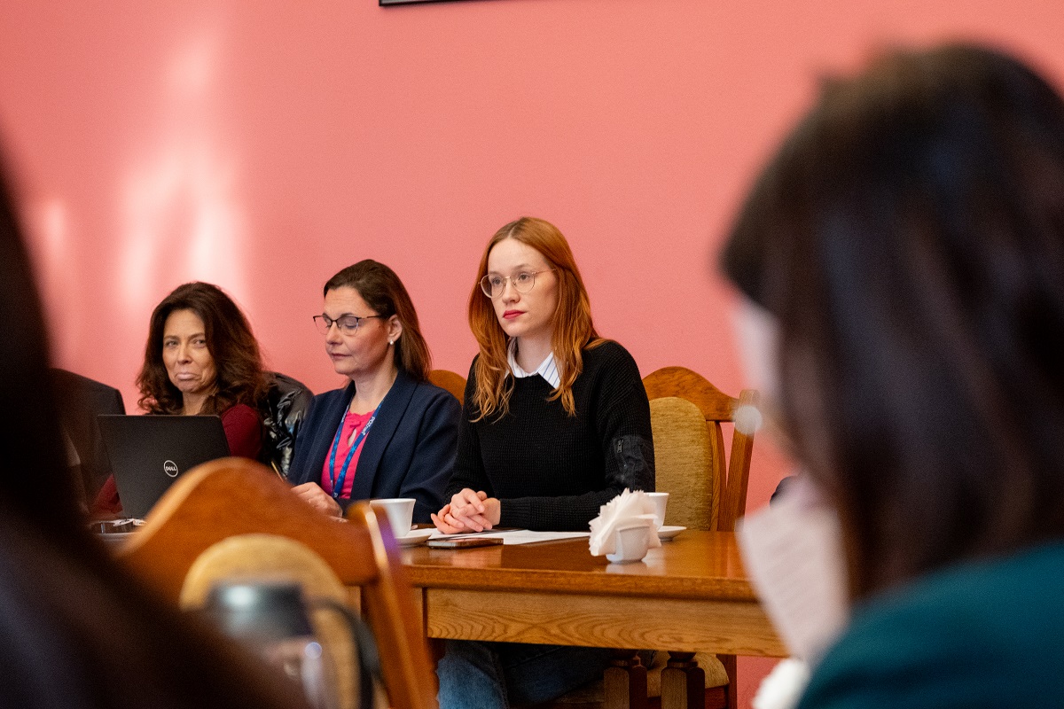 kilka osób siedzi za stołem w sali konferencyjnej siedzą trzy kobiety - więcej w treści artykułu