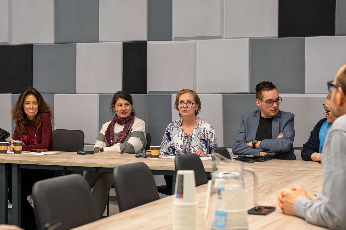 kilka osób siedzi za stołem w sali konferencyjnej - więcej w treści artykułu