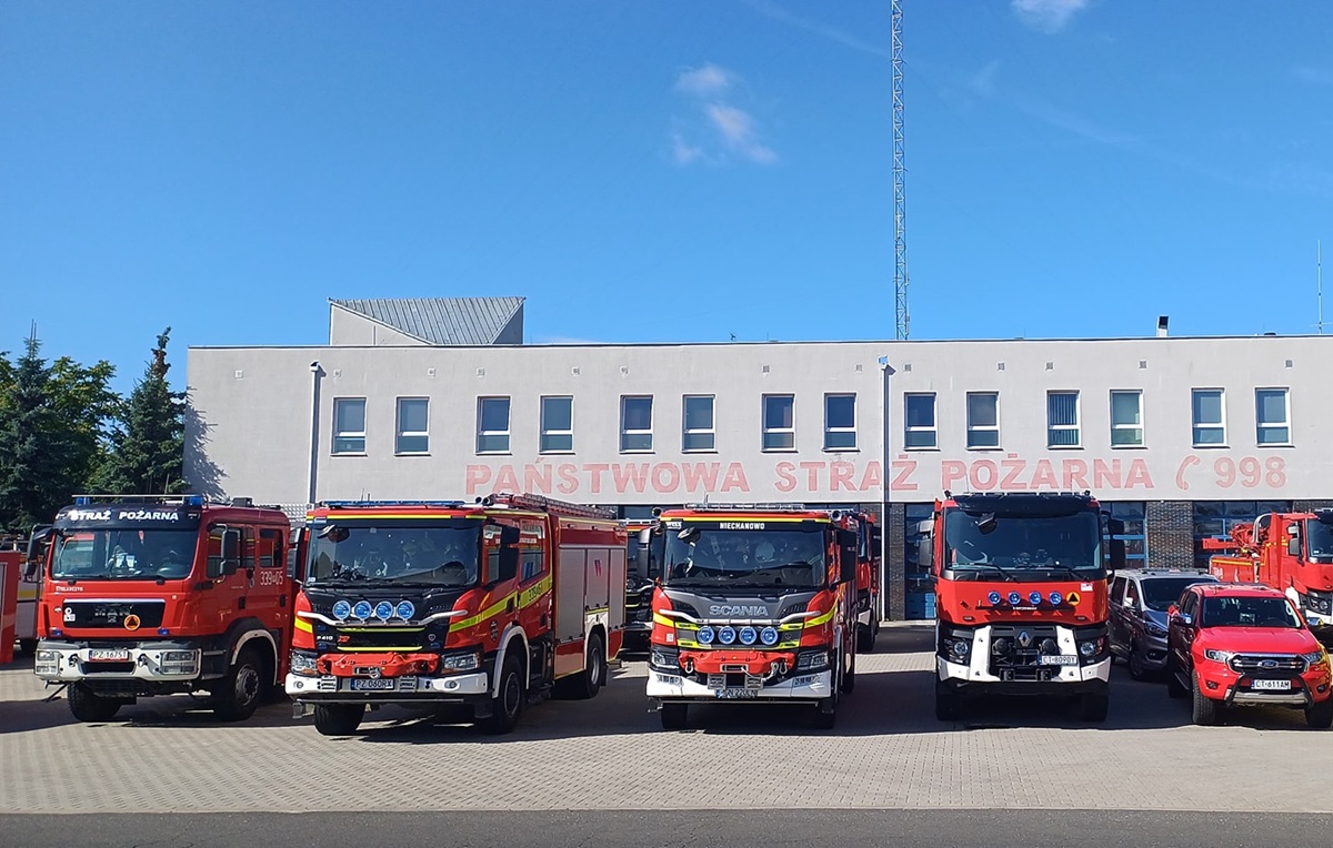 kilka wozów strażackich przed budynkiem straży pożarnej