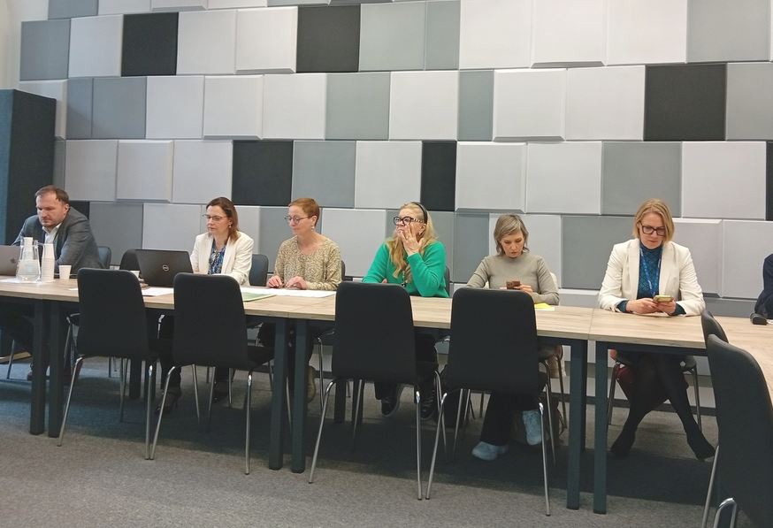 kilkoro osób siedzi w sali przy stole konferencyjnym - grafika artykułu