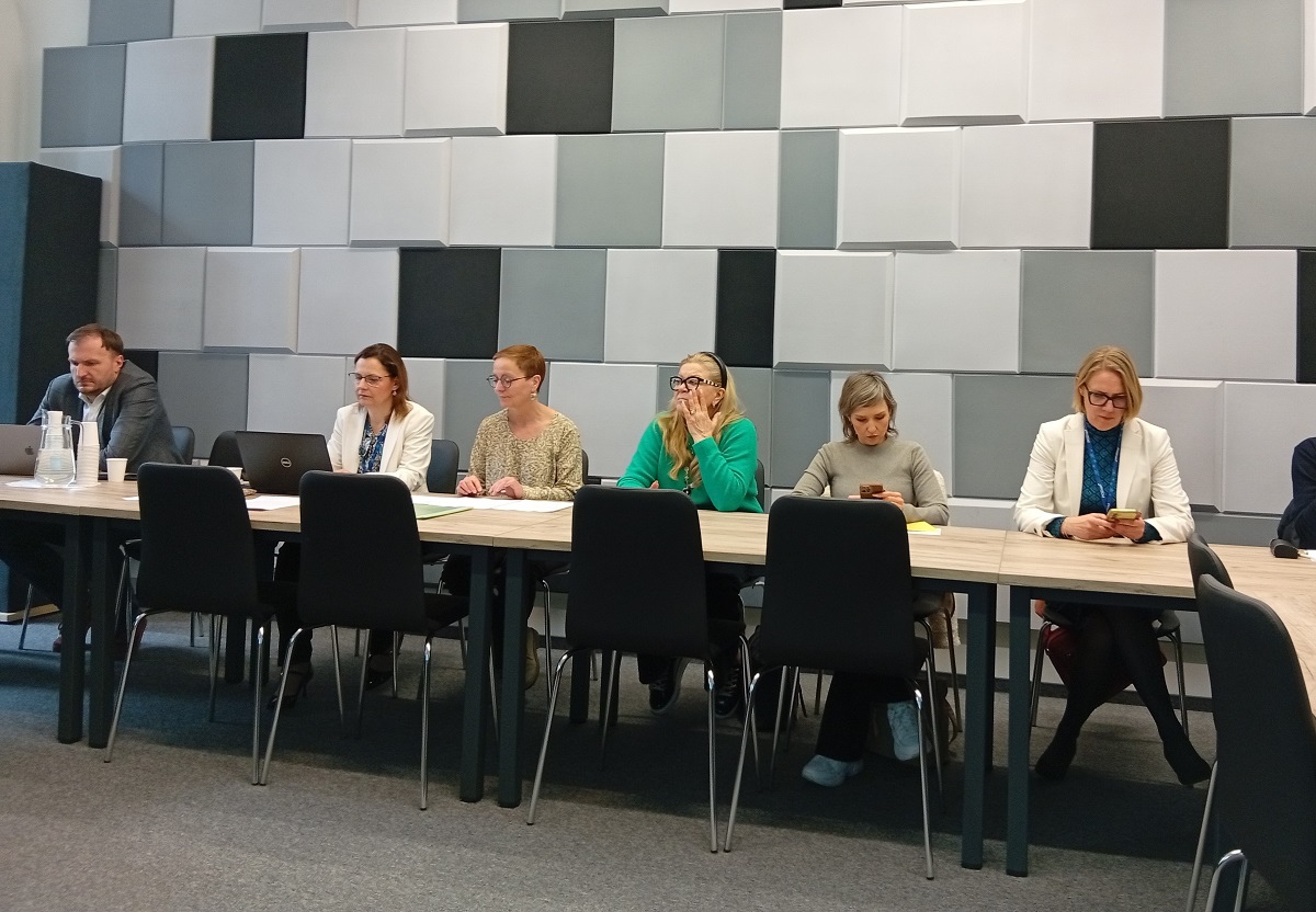 kilkoro osób siedzi za stołem w sali konferencyjnej - grafika artykułu