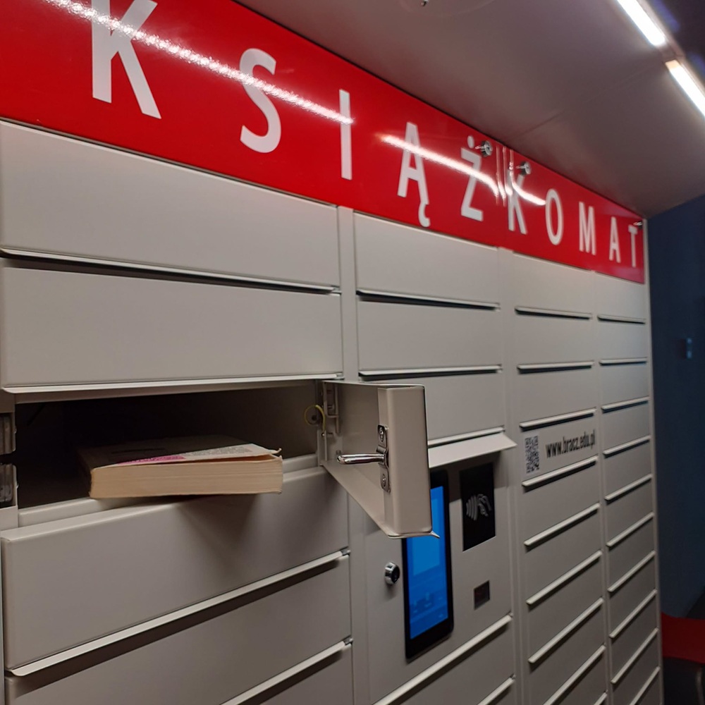 Ksiązkomat, jedna ze skrytek otwarta, widać leżącą w niej książkę
