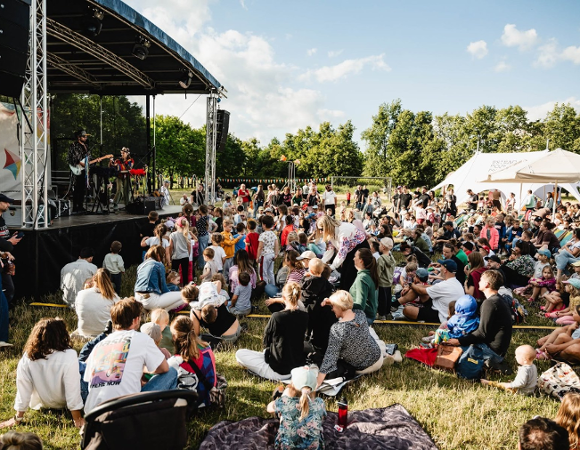 Ludzie siedzący przed sceną w parku