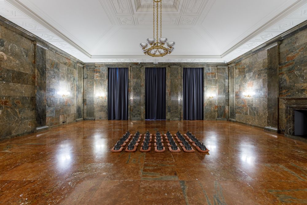 Małe figury ustawione w równych rzędach na podłodze.