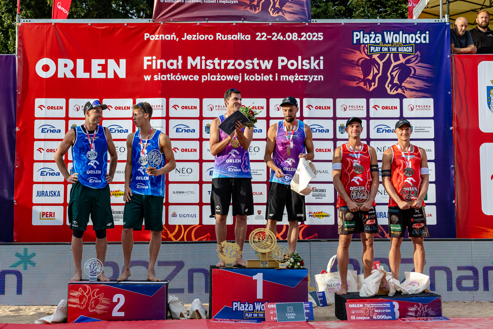 Medaliści Orlen Finału Mistrzostw Polski w siatkówce plażowej mężczyzn, fot. Piotr Rychter - na podium z medalami i nagrodami stoją 3 pary męskie