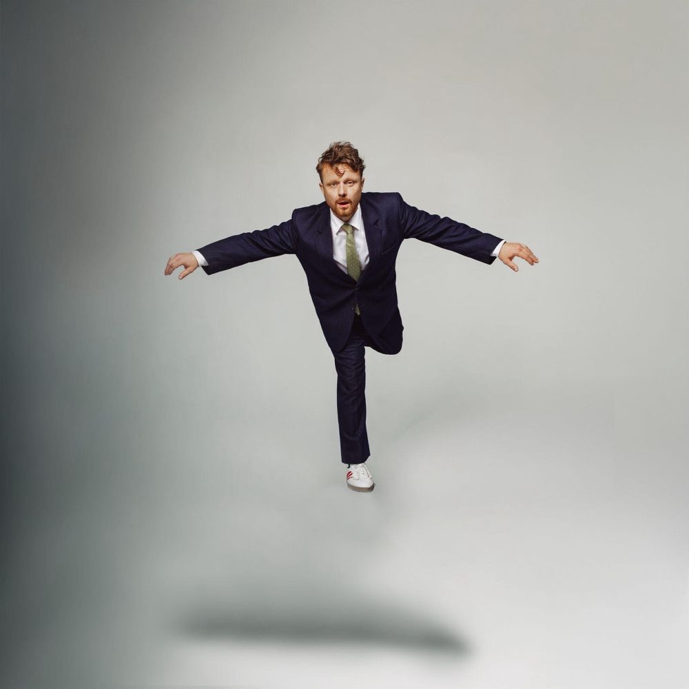 Mężczyzna w garniturze unosi się nad ziemią.