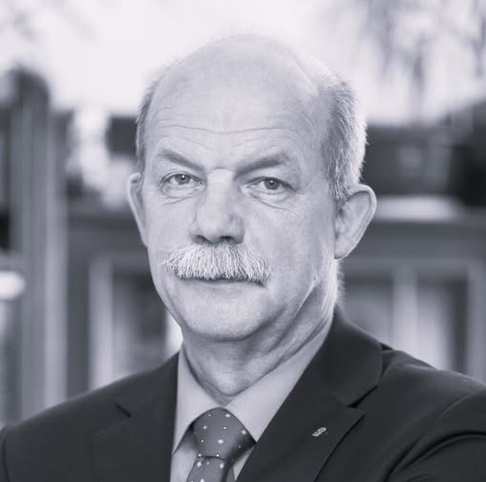 Mężczyzna z wąsem i pod krawatem.