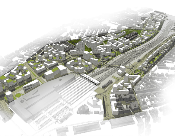 Model architektoniczny lub wizualizacja urbanistyczna dużej części miasta z lotu ptaka. Dominują nowoczesne, geometryczne bloki budynków w kolorach białym i szarym, z zielonymi dachami. W centralnej części widoczne tory kolejowe i duży, szary teren dworca, a także obszar planowanej zabudowy.