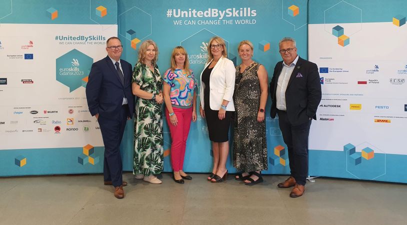 Na grafice zaprezentowano 4 kobiety oraz 2 mężczyzn przy plakacie #Unitedbyskills