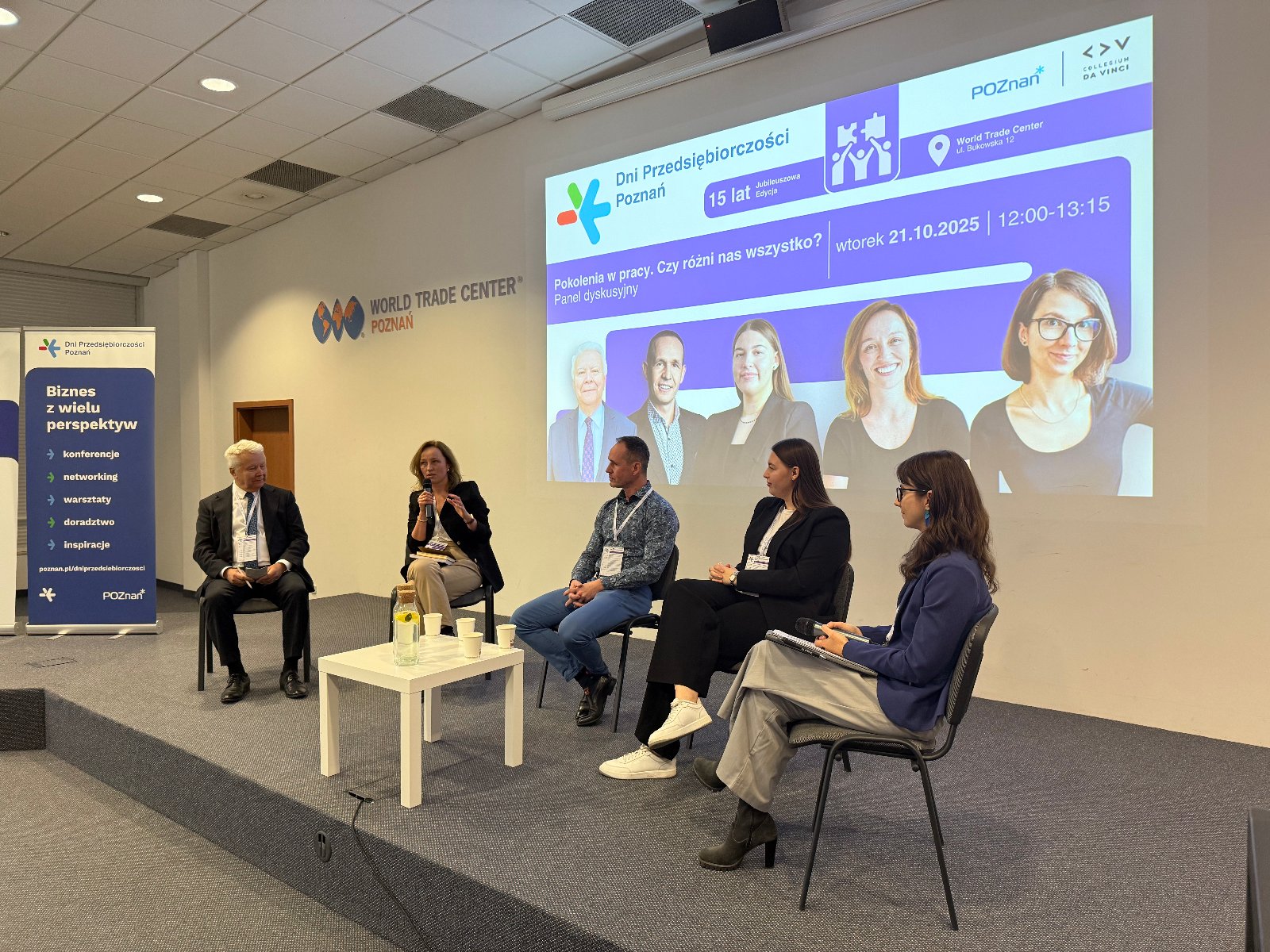 Na scenie trwa panel dyskusyjny podczas konferencji "Buduj siebie i zespół. Zrozum różnice, wykorzystaj potencjał". Przy stole siedzi czworo ekspertów - dwóch mężczyzn i dwie kobiety - rozmawiających o współpracy międzypokoleniowej w miejscu pracy. Obok stoi moderatorka prowadząca rozmowę. W tle widać ekran z tytułem panelu, a przed sceną - publiczność uważnie słuchającą dyskusji.