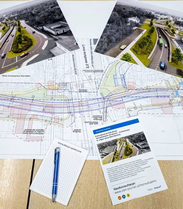 Na stole leży mapa z koncepcją drogową, wizualizacje, ulotka konsultacyjna i długopis