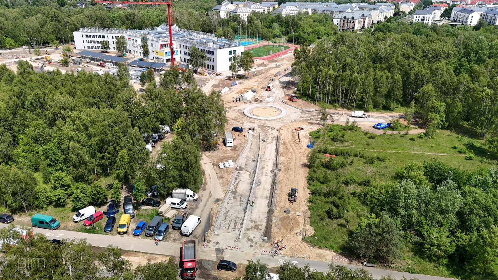 Na zdjęciu budowa drogi widziana z lotu ptaka, w tle widać szkołę