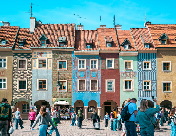 Na zdjęciu domki budnicze, przed nimi spacerujący ludzie