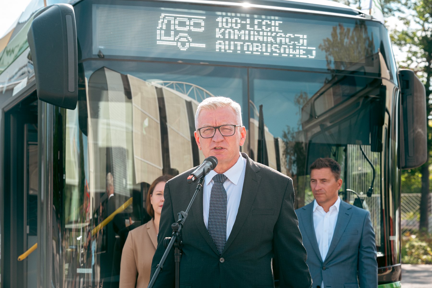 Na zdjęciu dwa autobusy, na pierwszym planie rośliny