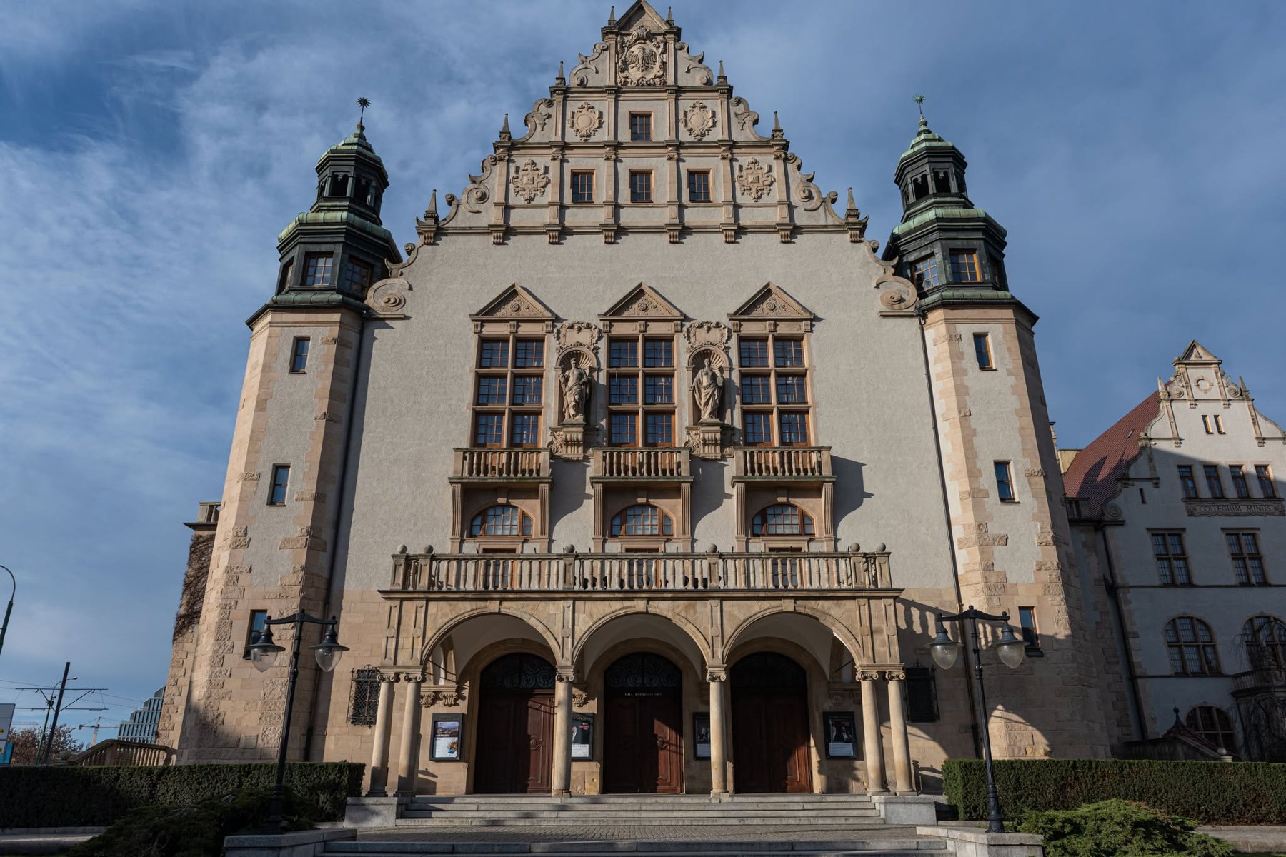 Na zdjęciu dwa krzyże z Pomnika Poznańskiego Czerwca, na pierwszym planie drzewa