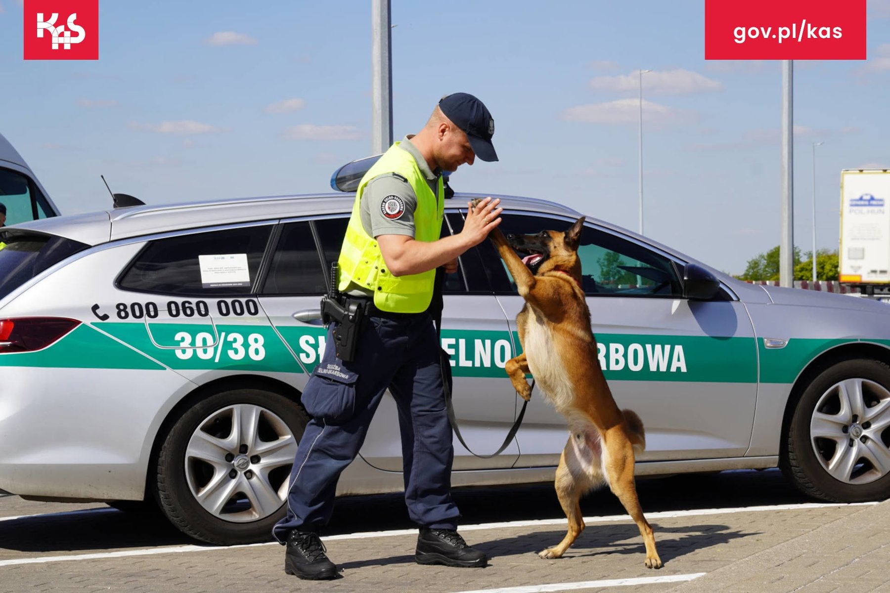 Na zdjeciu dwoje funkcjoinariuszy policji, uśmiechniętych, pokazujących uniesione w górę kciuki
