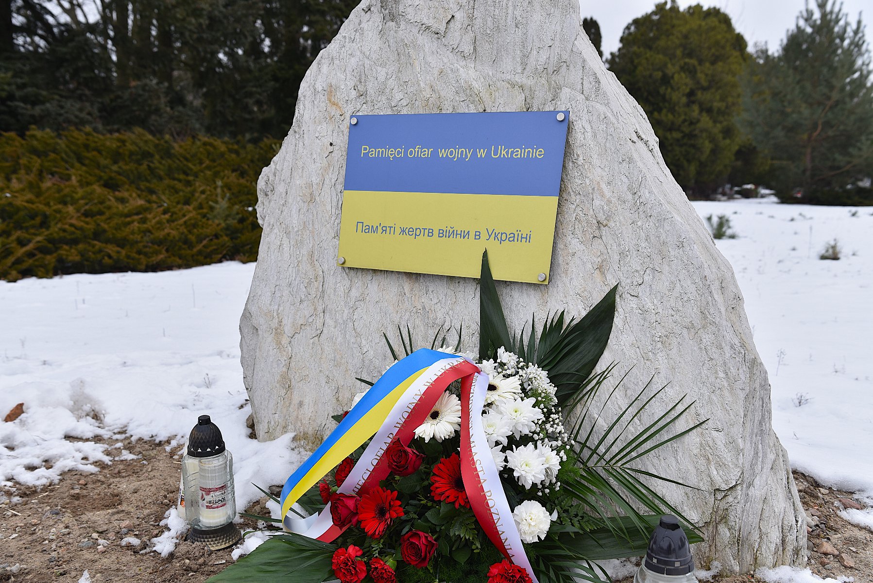 Na zdjęciu głaz z napisem: pamięci ofiar wojny w Ukrainie, pod nim leży wiązanka kwiatów