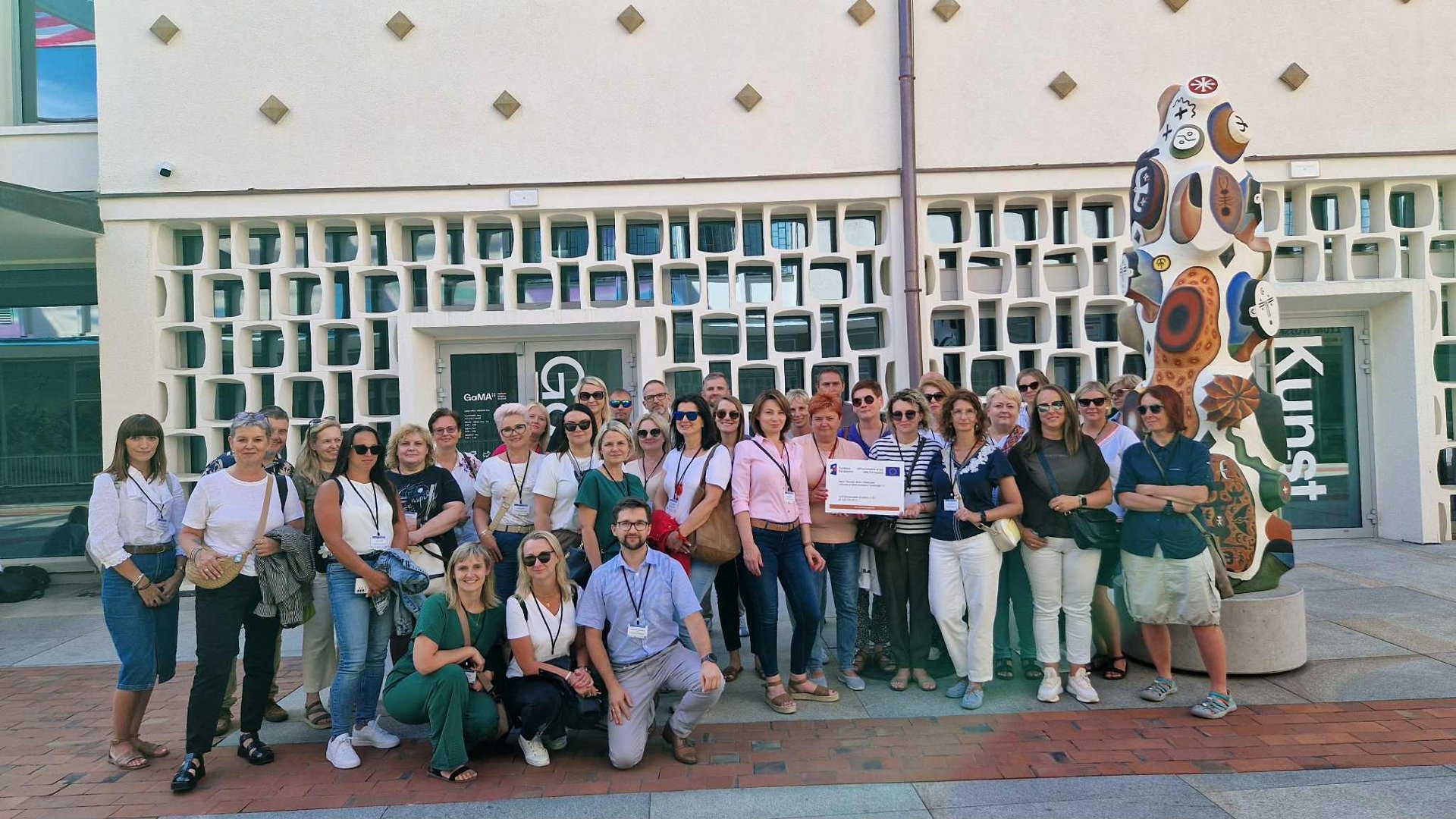 Na zdjęciu grupa samorządowców z wizyty studyjnej stoja przed Galeria Arsenał w Poznaniu