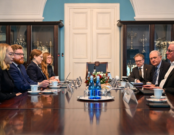 Na zdjęciu kilka osób siedzących przy dużym stole w reprezentacyjnej sali urzędu miasta