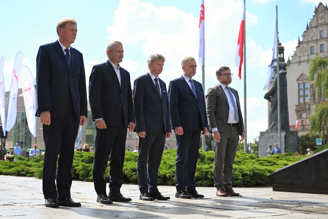 Na zdjęciu kwiaty leżące pod pomnikiem