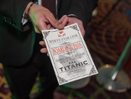 Na zdjeciu mężczyzna podający kartę - bilet na "Titanica", widać tylko jego dłonie