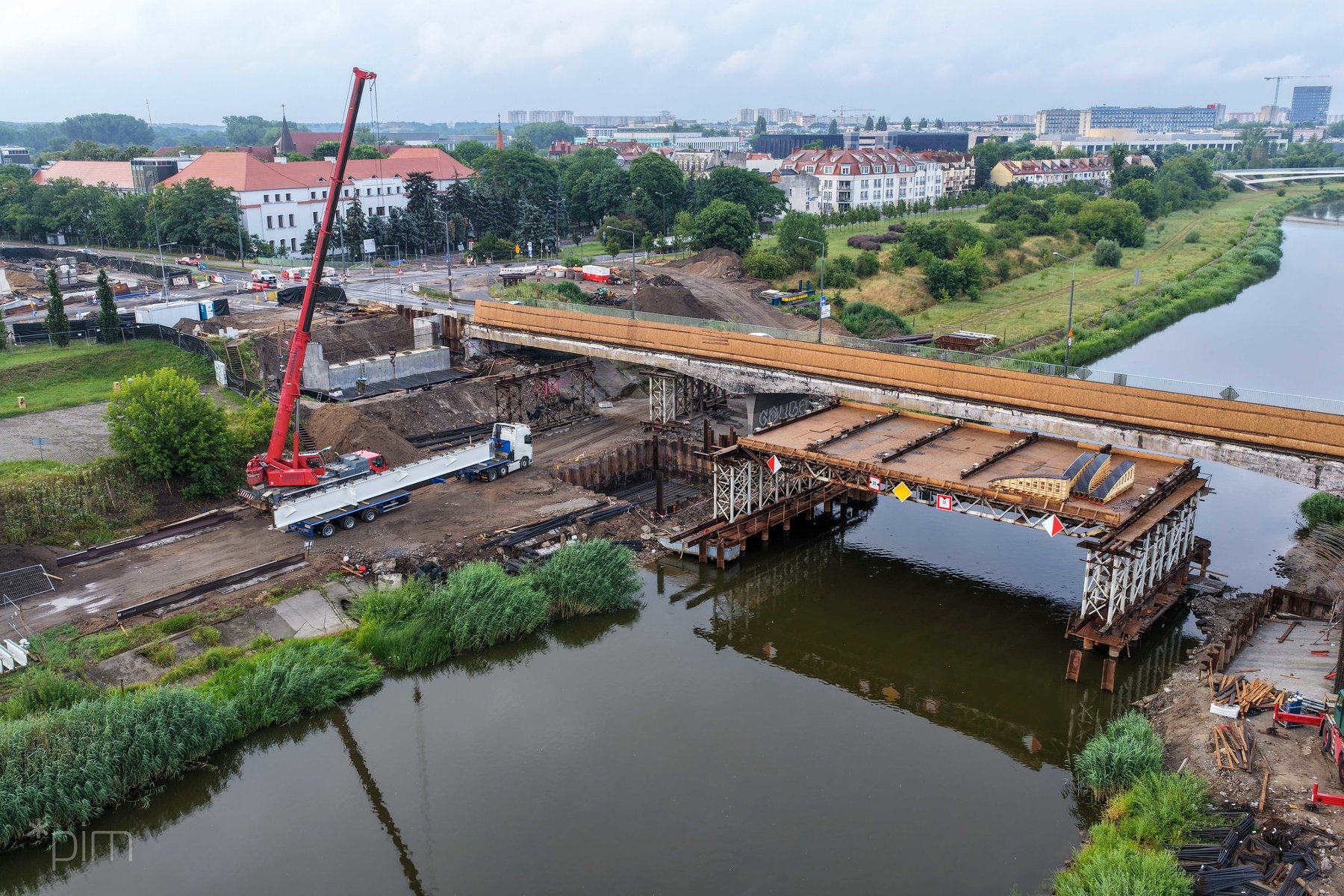 Na zdjęciu most widziany z lotu ptaka, widać ciężarówkę z dużym elementem mostu