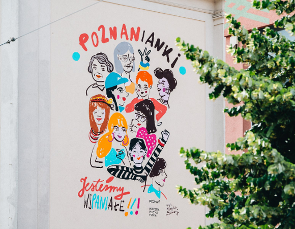 Na zdjęciu mural z twarzami kobiet i napisem: jesteśmy wspaniałe