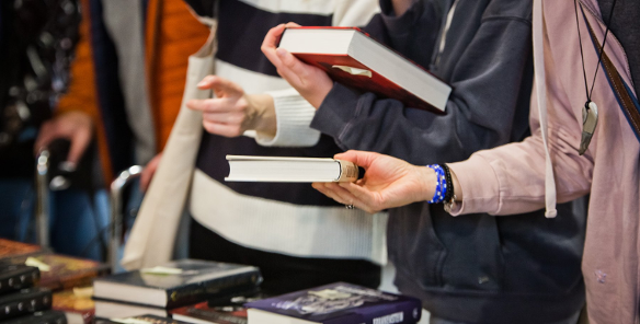 Na zdjęciu osoby trzymające książki