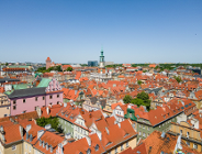 Na zdjęciu panorama Poznania, widać czerwone dachy kamienic i wieżę Ratusza