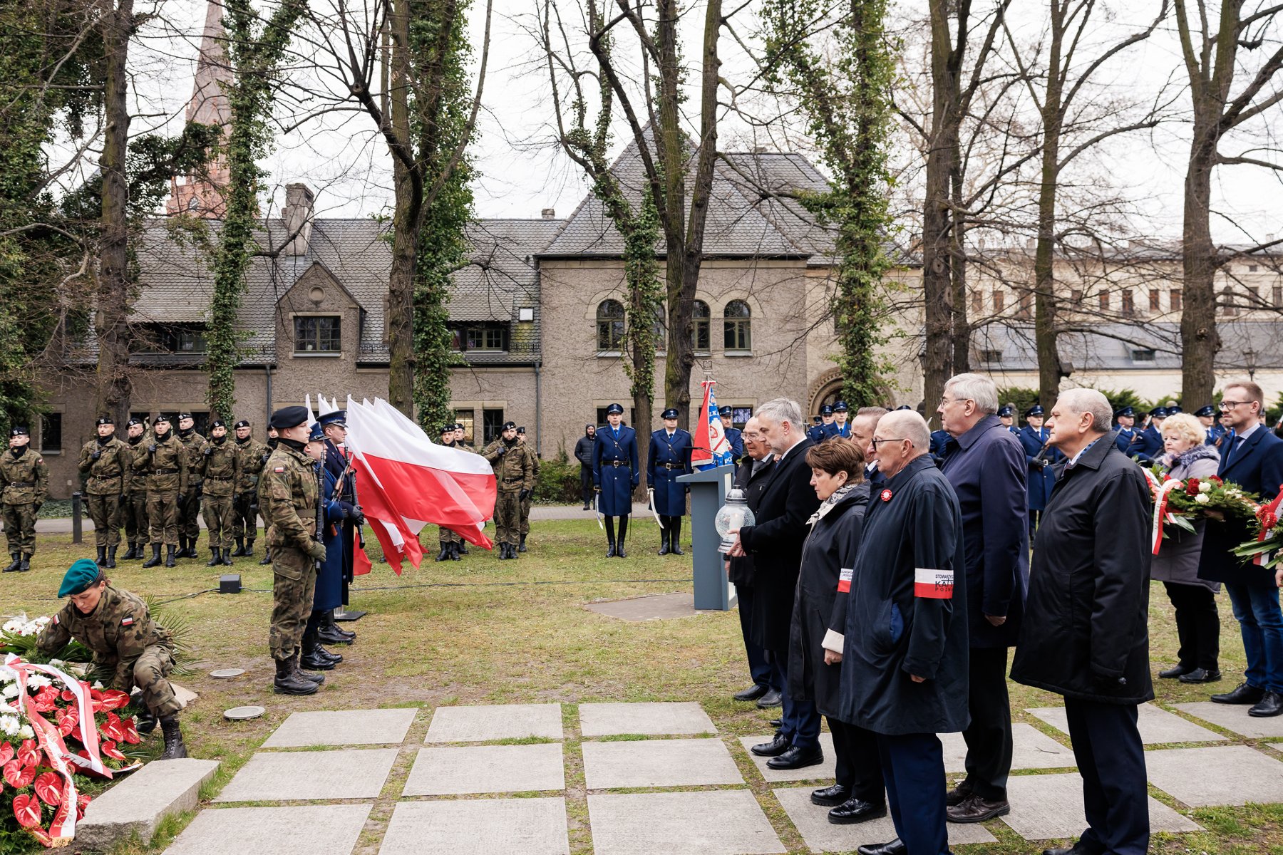 Na zdjęciu pomnik w ogrodzie CK Zamek, obok żołnierze i mężczyzna mówiący coś z mównicy