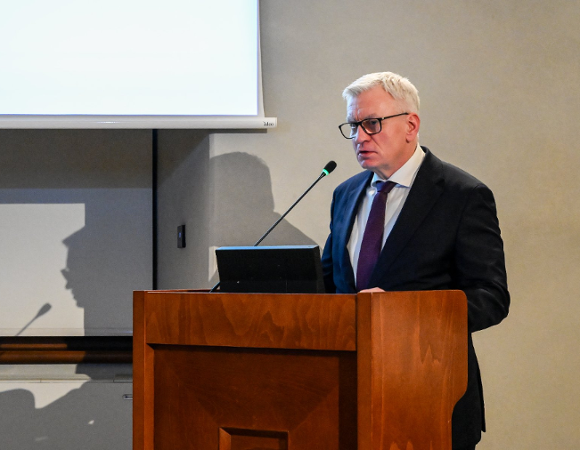 Na zdjęciu prezydent Poznania mówi coś przy mównicy w sali sesyjnej