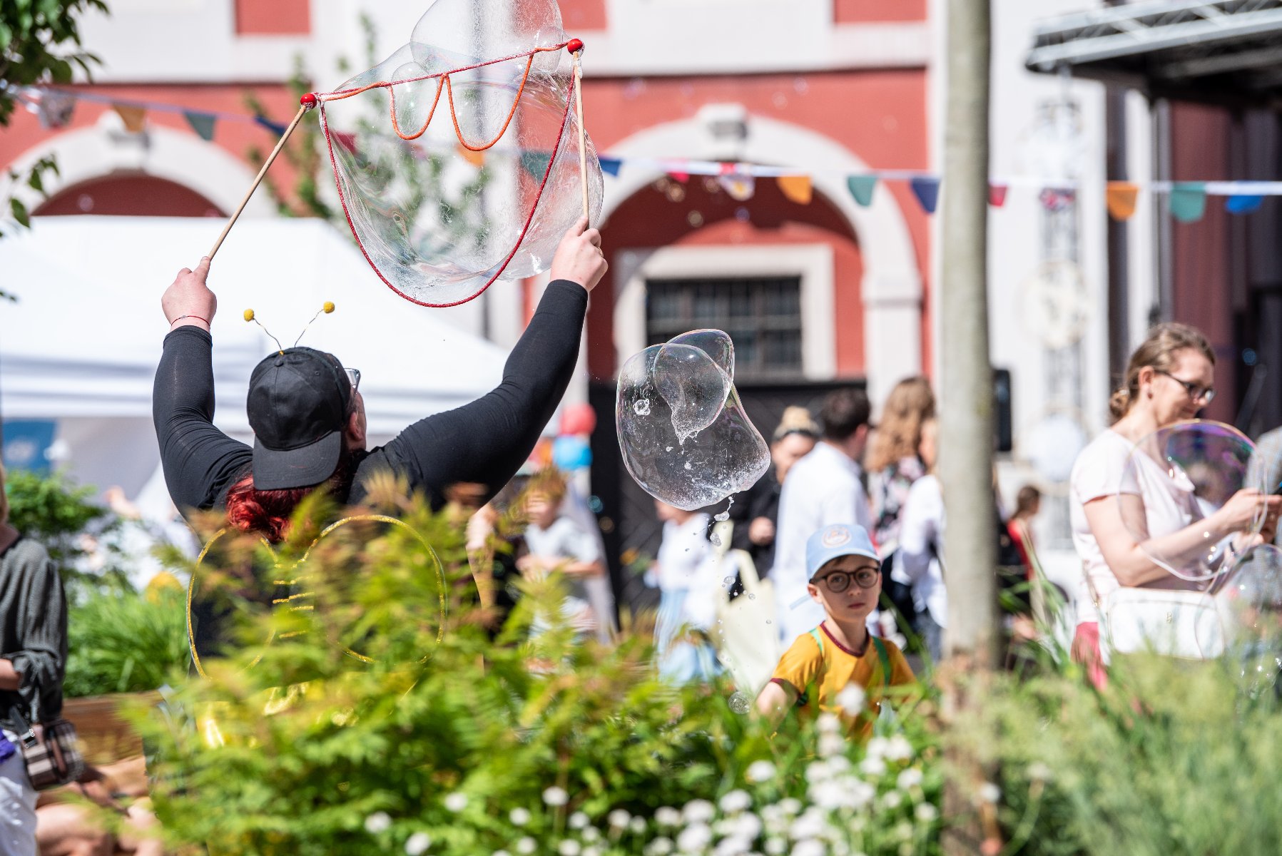 Na zdjęciu Stary Rynek w Poznaniu, na pierwszym planie dziecko siedzące na plecach dorosłego