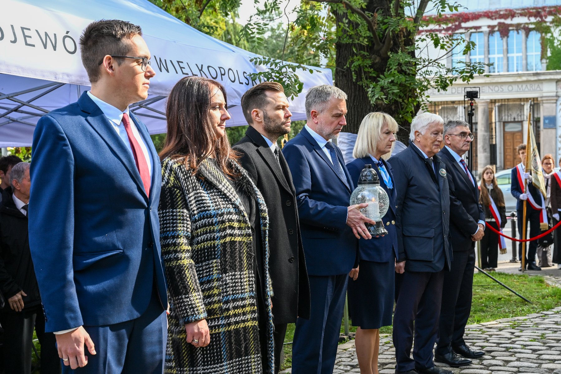 Na zdjęciu tabliczki nagrobne, na nich znicze i wieńce