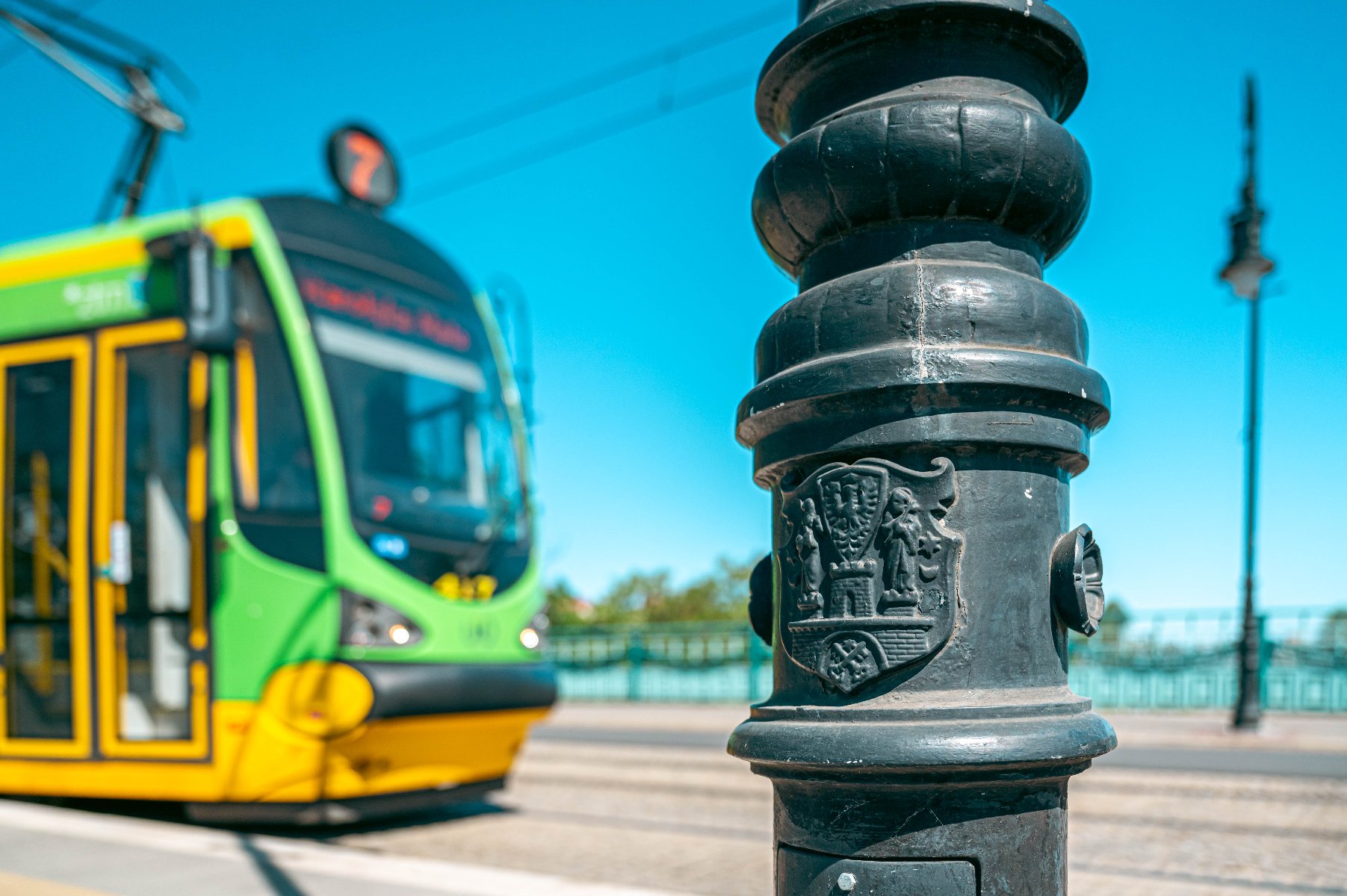 Na zdjęciu tramwaj, przed nim hydrant z herbem miasta