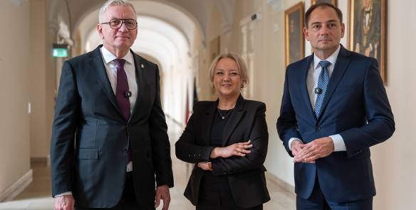 Na zdjęciu trzy osoby, dwóch mężczyzn i kobieta, stojących w korytarzu urzędu