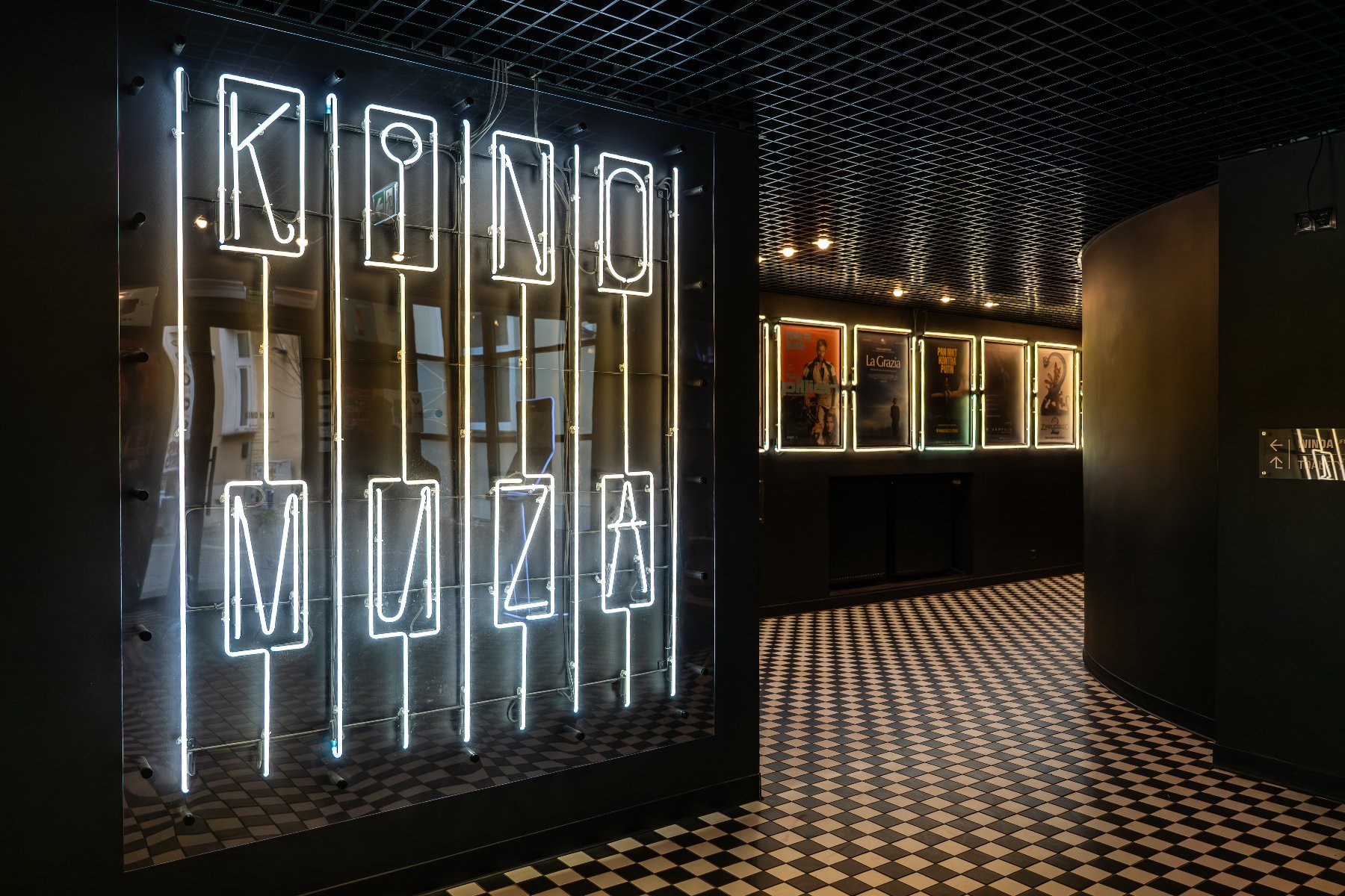 Na zdjęciu wnętrze Kina Muza, widać neon i korytarz z plakatami