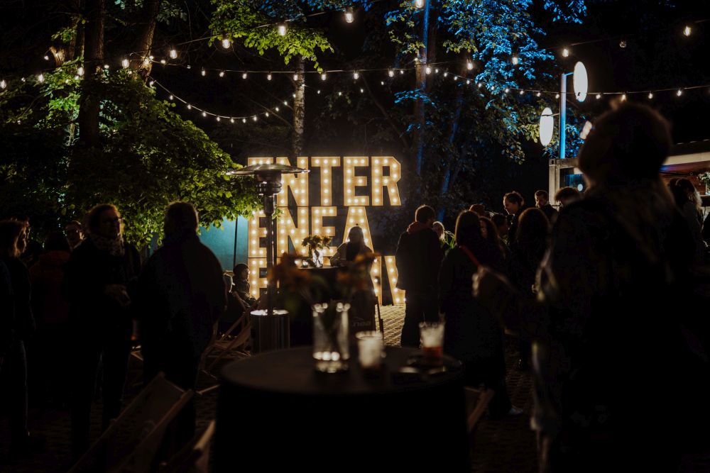 Neonowa nazwa festiwalu świecąca w ciemności.