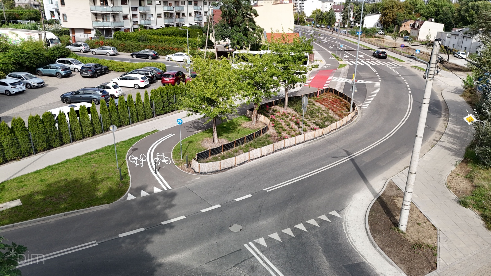 Nowa droga rowerowa wzdłuż ul. Dmowskiego. Chodnik, drzewa i zieleń.